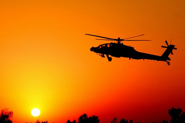 Sylwetka startującego helikoptera o zachodzie słońca