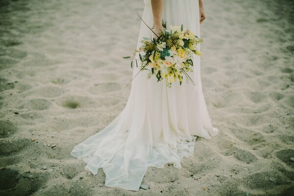 Novia con un ramo brillante en la playa