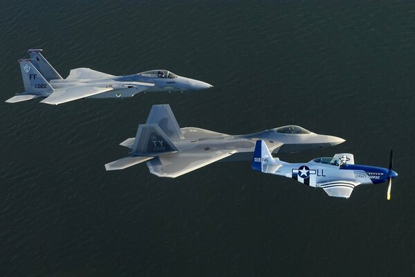 Tres aviones de combate vuelan sobre un fondo oscuro