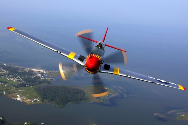 A plane with propellers flies over islands and water