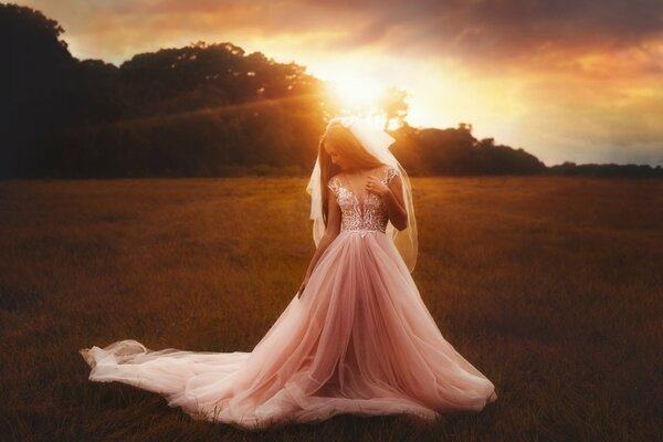 Chica con vestido de novia de pie en el campo