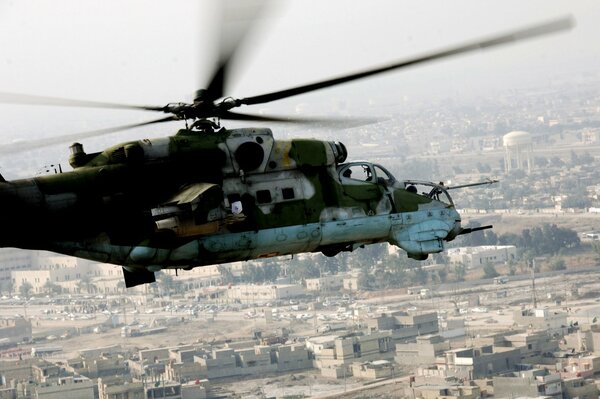 The Mi-24 helicopter flies against the background of the city