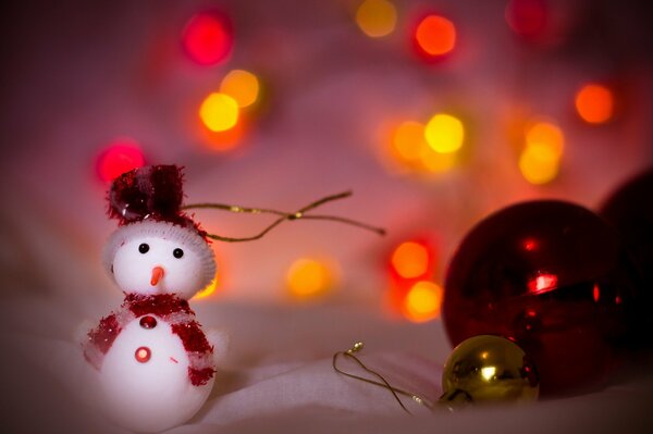 Bonhomme de neige jouet à côté de boules rouges