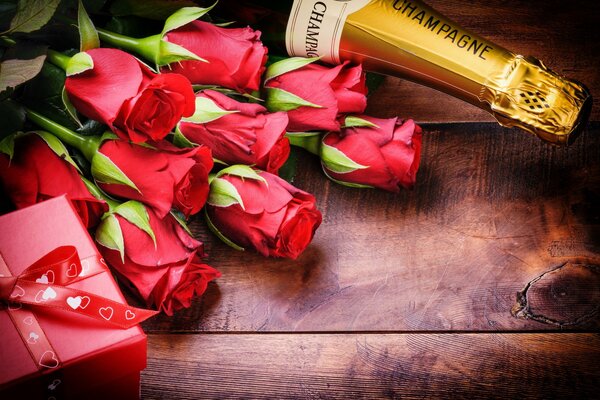 Red roses with a box with a bow and champagne