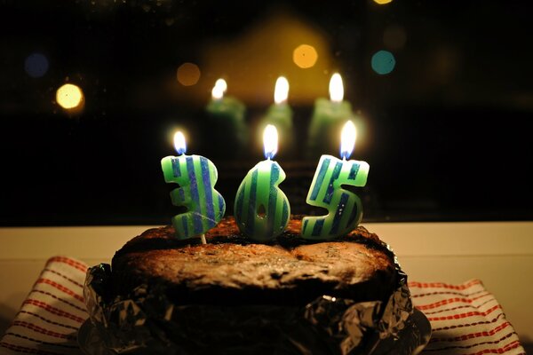 A birthday cake with candles is reflected in the mirror