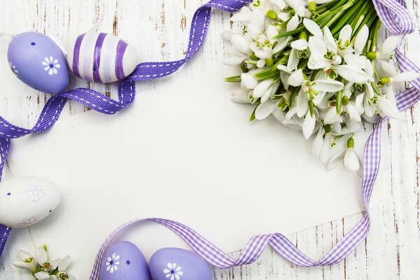 Beautiful Easter spring background with snowdrops, ribbons and eggs