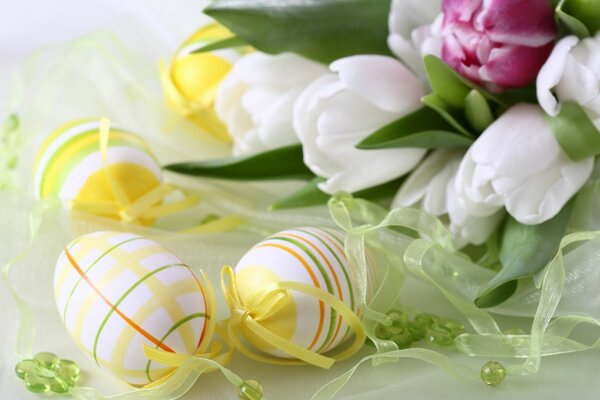 Huevos de Pascua en la mesa con cintas y flores