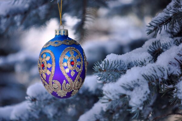 Weihnachtskugel auf einem schneebedeckten Ast