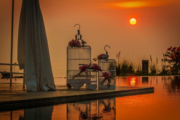 White bird cages on the sunset background