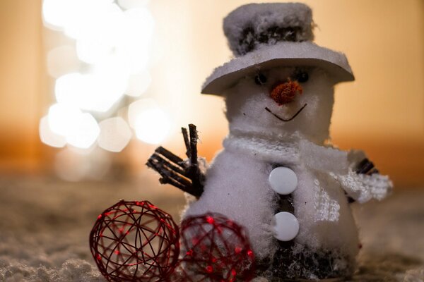 A snowman with a hat and two red decorative balls