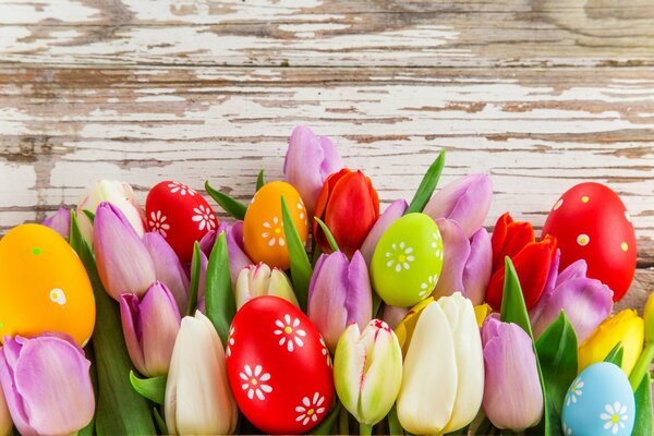 Huevos de Pascua y tulipanes en la mesa