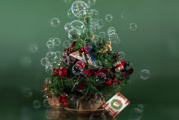 Piccolo albero di Natale con giocattoli su sfondo verde