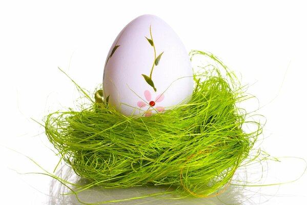 Easter egg with a pattern in a light green nest made of grass