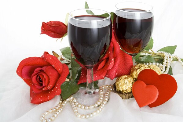 Romantic table for two lovers. Delicious red wine, sweets and flowers