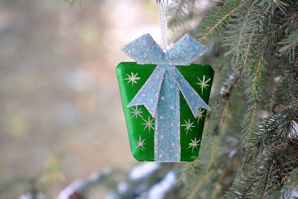 Petit cadeau dans l emballage vert accroché sur l arbre de Noël