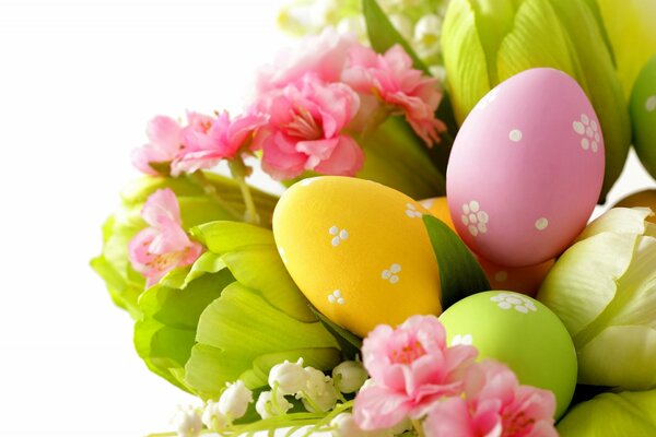 Painted eggs in a bouquet of tulips and lilies of the valley