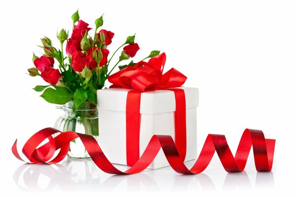 Geschenk mit roter Schleife und Rosen