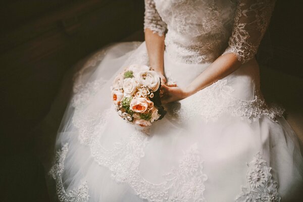 The bride holds her bouquet sitting alone