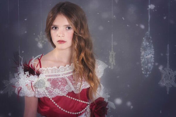 A girl in a fancy dress on a background of snowflakes