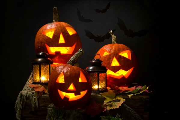 Pumpkin with lanterns and autumn leaves on the table