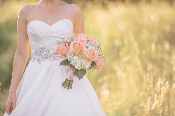 Foto de boda. La novia con un ramo. Foto en el campo