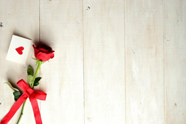 A rose with a cute ribbon and a card with a heart