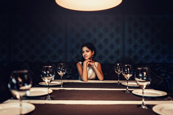 Brünette Mädchen am Tisch mit Gläsern