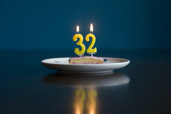 A piece of birthday cake with candles 32. In