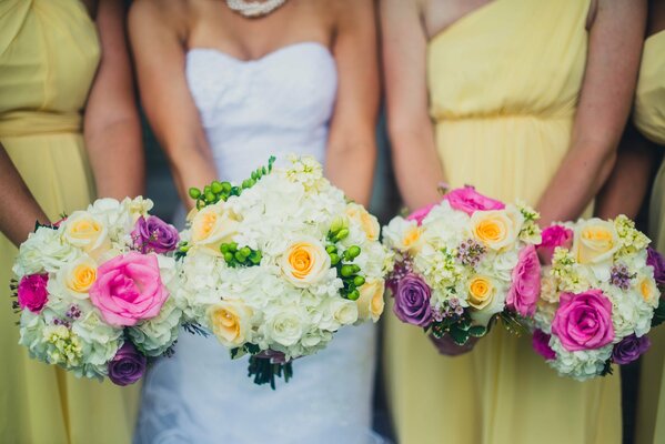 Bridesmaids with bouquets of roses