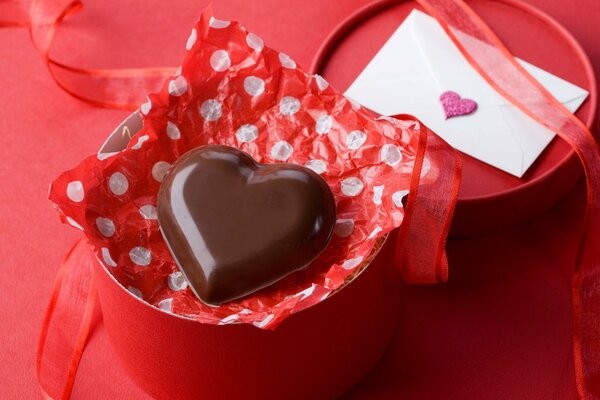 Caramelo de chocolate en forma de corazón y una carta al lado