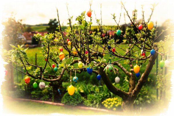Branches de printemps dans les feuilles épanouies décorées avec des oeufs de Pâques