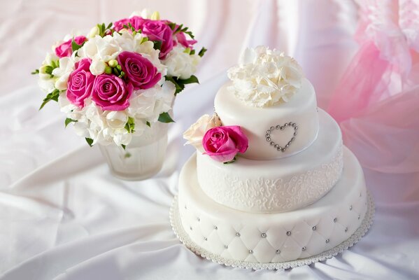A wedding cake with a bouquet of flowers is on the table