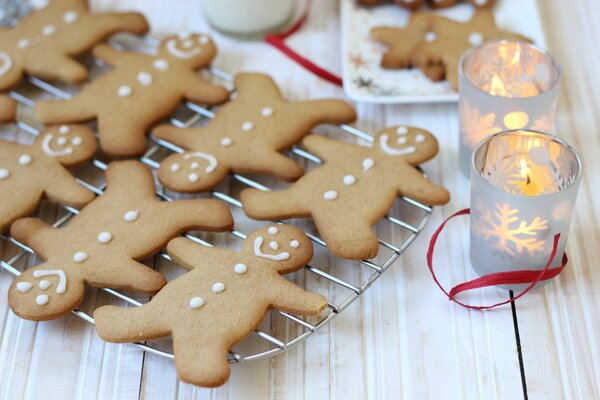 Festiva año nuevo y Navidad Ginger Gingerbread en forma de hombrecillo con cara sonriente y vela encendida en el candelero