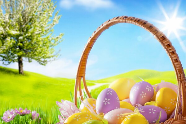 Basket with Easter eggs in the meadow