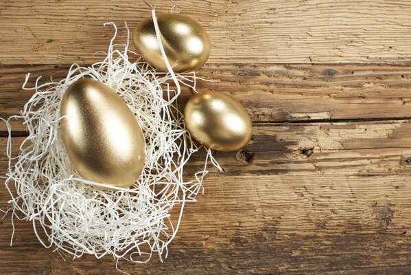 Golden eggs on a wooden background