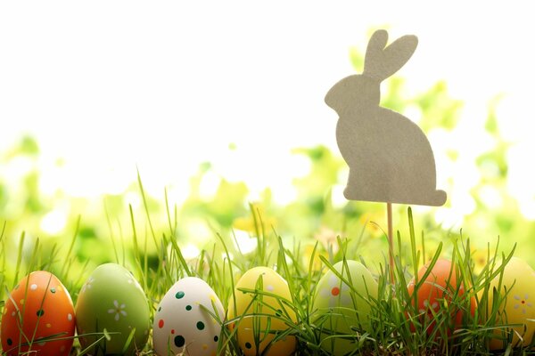 Huevos de Pascua en la hierba con una figura de conejo