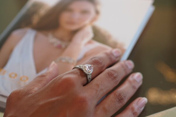 Mano femminile con anello sopra la foto di nozze