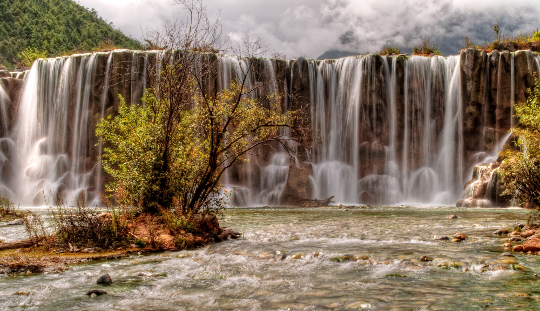 yulong snow mountain china mountain river stones rock waterfall