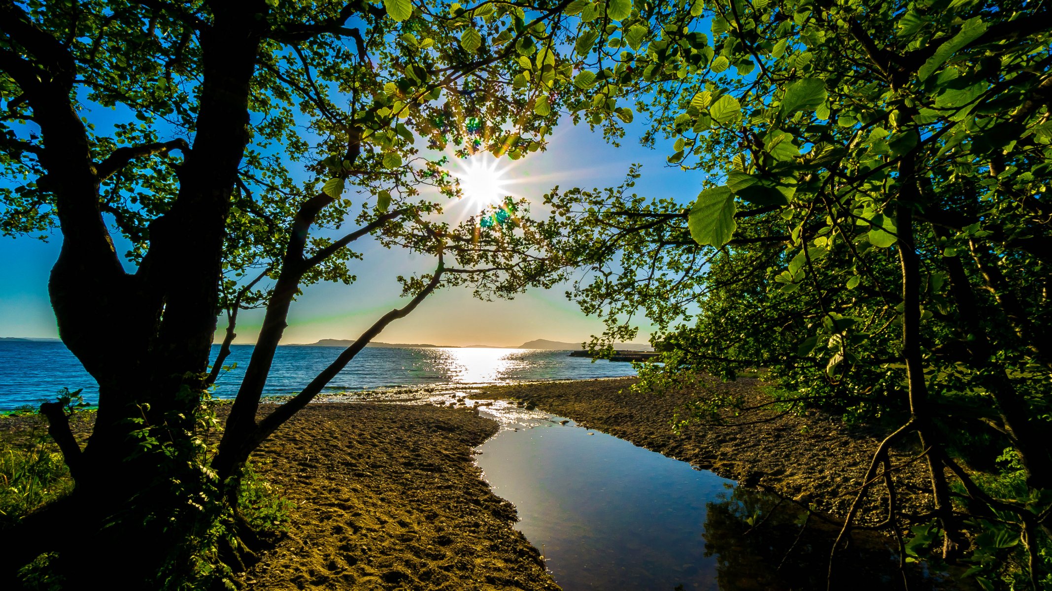 ciel soleil rayons montagnes mer arbres lac canal