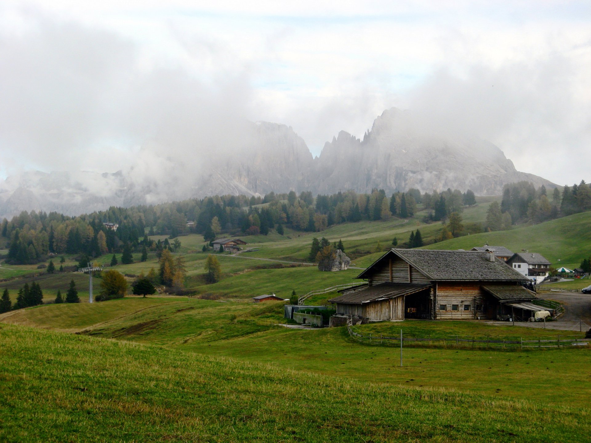 italien seiser alm felder wiesen berge alpen häuser wolken