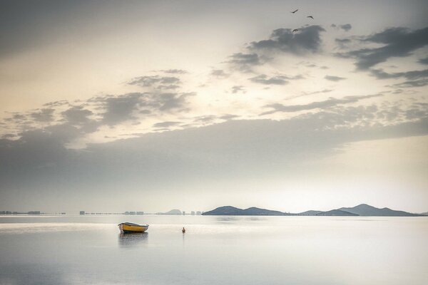 Paisaje con un barco en medio del lago en escala de grises