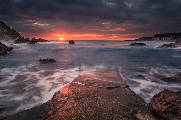 Coucher de soleil sur fond de mer sur un rebord de falaise solitaire