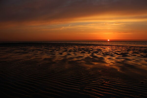 Coucher de soleil rouge sur la côte de la mer