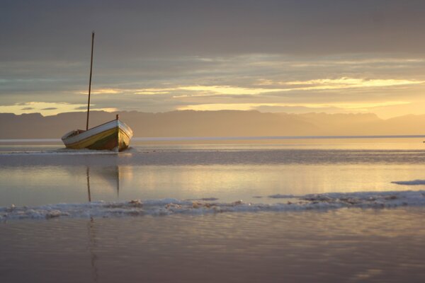 Bateau échoué au coucher du soleil. En mer