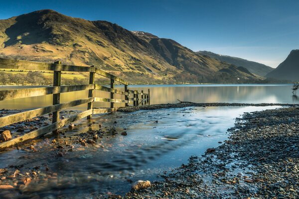 Rocky shore at sunset fence