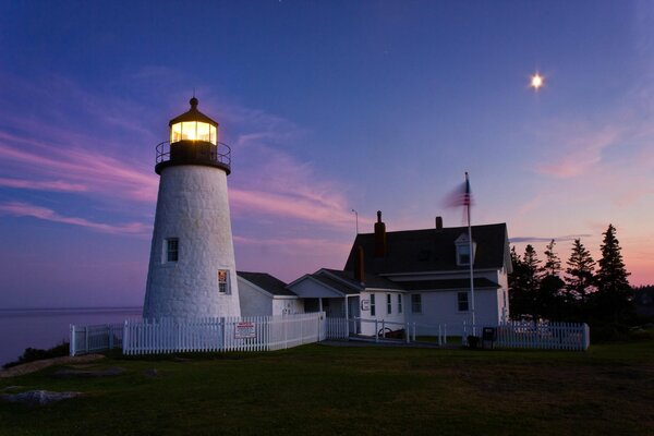 A white lighthouse in a purple sunset