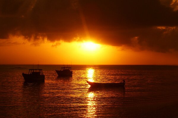 Coucher de soleil rouge sur la mer avec des bateaux