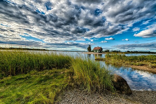 Maison près de l eau sur fond de nuages