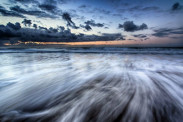 The sun set in the clouds. Evening sea