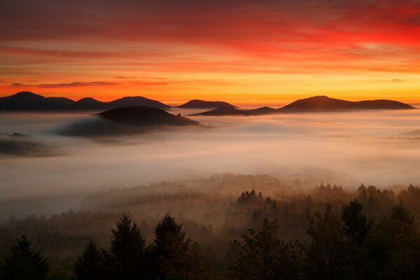 Amanecer más allá de las nubes sobre las montañas